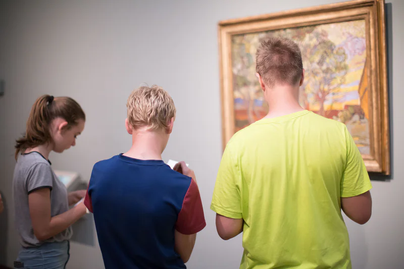 Twee jongens en een meisje maken opdrachten bij het schilderij De tuin van de inrichting (1889) van Vincent van Gogh. foto: Brenda Roos